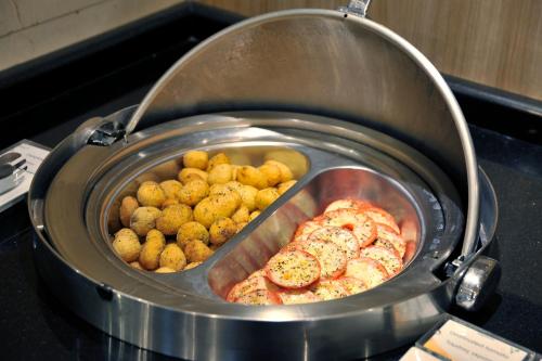 a pan filled with meat and potatoes on a stove at Melia Athens in Athens