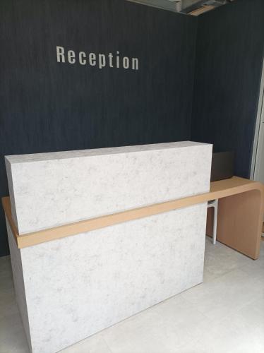 a reception desk in an office next to a wall at 7Rizes Luxury Living in Heraklio Town