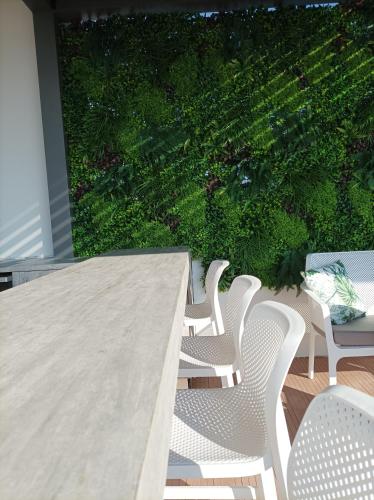 a table with white chairs and a large window at 7Rizes Luxury Living in Heraklio Town