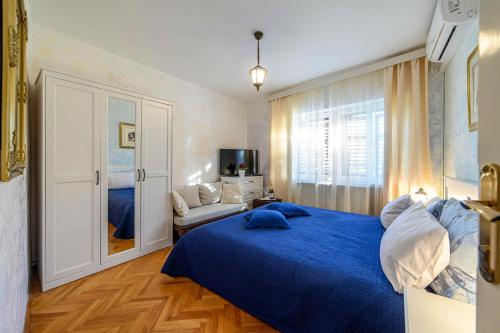 a bedroom with a blue bed and a couch at Wine Garden Rooms in Skradin