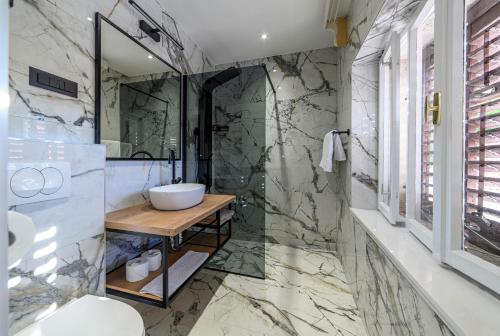 ein Bad mit einem Waschbecken und einem Spiegel in der Unterkunft Wine Garden Rooms in Skradin