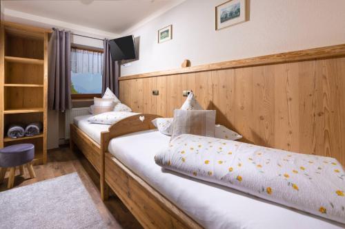 two twin beds in a room with a tv at Gästehaus Lärcheck Berchtesgaden FeWo Gipfelzauber in Berchtesgaden