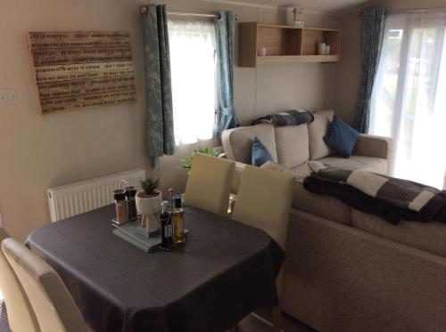 a living room with a table and a couch at Lake District Western 2-Bed Cabin Pet Friendly in Wigton