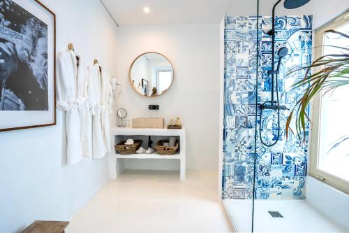 een badkamer met een douche met blauwe en witte tegels bij Suites D´aldeia - Suite 20 in Mafra