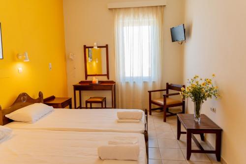 a hotel room with two beds and a mirror at Almyra Apartments & Suites in Sfakaki
