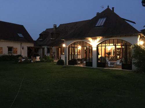 a house with a lit up front yard at night at Les Prémices De La Forêt in Chailly-en-Bière