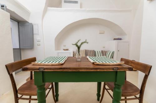 a table with two chairs and a green table at Casa Marta holiday home - "exclusive typical Salento house in historic center" in Tricase