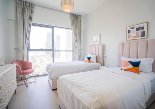 - 2 lits dans une chambre d'hôtel avec fenêtre dans l'établissement Nasma Luxury Stays - Bellevue Tower 1, à Dubaï