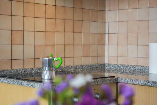 a green coffee mug on a counter in a kitchen at Chiara Lovely Apartment in Tirana