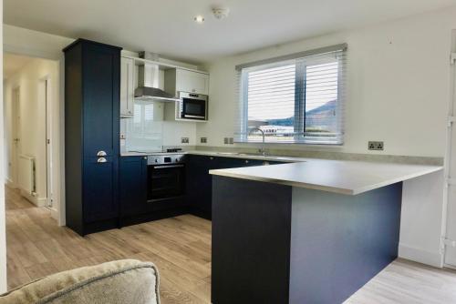 a kitchen with black and white cabinets and a counter at Castle View Chalet by Clonlum Cottages in Newry