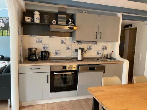 a small kitchen with white cabinets and a table at Lindenhof Habernis in Steinberg
