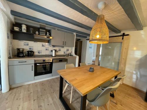 a kitchen with a wooden table and a light fixture at Lindenhof Habernis in Steinberg