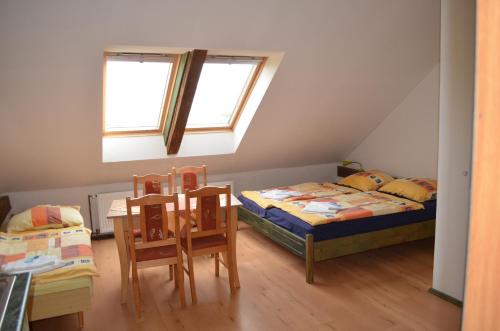 a bedroom with two beds and a table and chairs at Famozclub in Bakov nad Jizerou