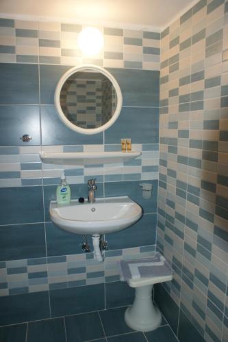 a bathroom with a sink and a mirror and a toilet at Hotel Eleftheria in Parikia
