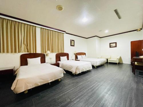 a hotel room with two beds and a piano at Abbo Hotel in Tainan