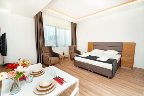 ein Hotelzimmer mit einem Bett und einem Esszimmer in der Unterkunft New Safir Apart Hotel in Lara