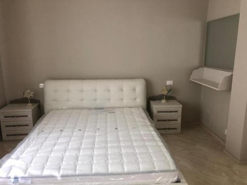 een wit bed in een kamer met 2 nachtkastjes bij Casa Vacanze Luigi&Maria in Pontremoli