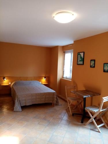 a bedroom with a bed and a table and chairs at La villa Rosace in Cerbère