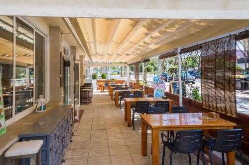 a restaurant with tables and chairs and windows at Hotel Hipica Park in Platja  d'Aro
