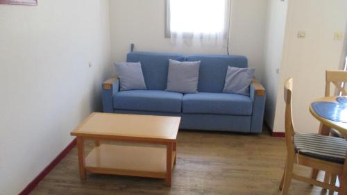 un canapé bleu dans un salon avec une table dans l'établissement Promenade des Bains Apartment, à Saint-Raphaël