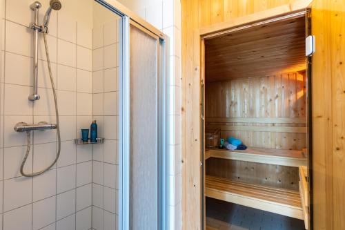 a shower with a wooden door in a bathroom at Antibes 232 - Kustpark Village Scaldia in Hoofdplaat