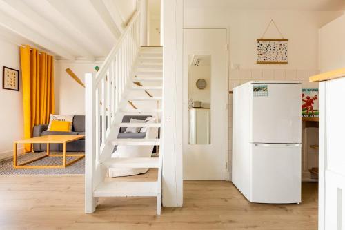 - un réfrigérateur blanc dans une chambre avec un escalier dans l'établissement West Green - Maison entre Dunes et Lac, à Le Touquet-Paris-Plage