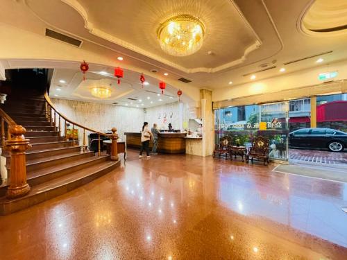 a lobby of a building with a person walking down the stairs at Abbo Hotel in Tainan