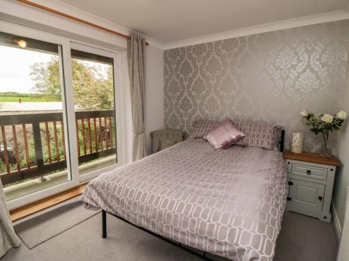 a bedroom with a bed and a large window at 5 Church View in Pickering