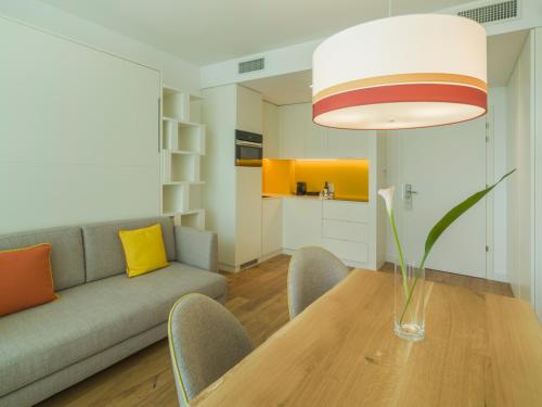 a living room with a table and a couch at Falkensteiner Residences Jesolo in Lido di Jesolo