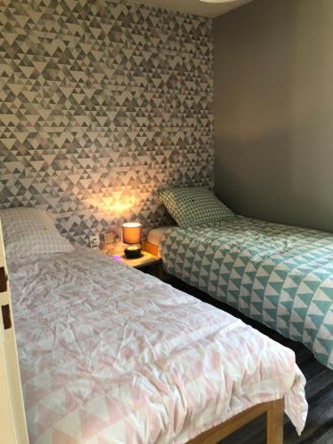 Signy-le-Petitにあるcottage chaleureux dans domaine privéのベッドルーム1室(ベッド2台、テーブルの上にランプ付)