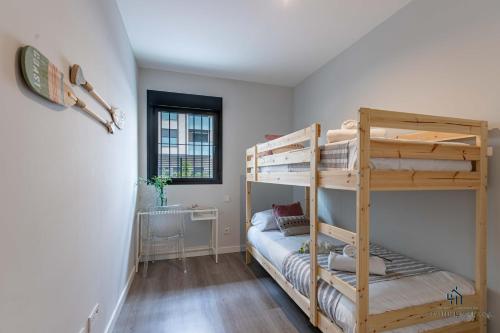 een slaapkamer met 2 stapelbedden en een raam bij Living4Malaga Pacific Terrace Apartment in Málaga
