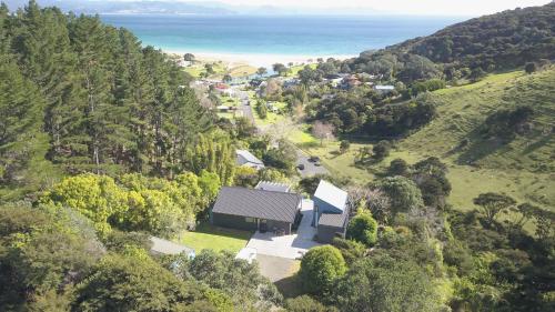 an aerial view of a house on a hill next to the ocean at Kuaotunu Escape in Kuaotunu