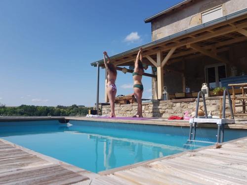 - deux personnes debout au bord d'une piscine dans l'établissement La Maison Du Curé, à Vougécourt