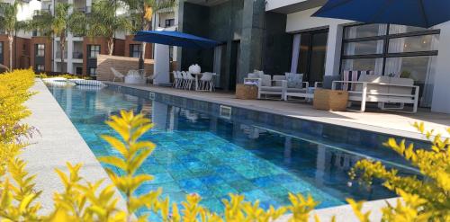 une piscine avec chaises et parasols à côté d'un bâtiment dans l'établissement MINT Resorts The Blyde, à Pretoria