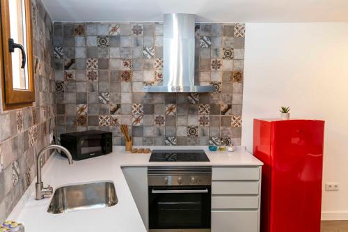 a kitchen with a stove and a red refrigerator at Casa Portelles in Denia