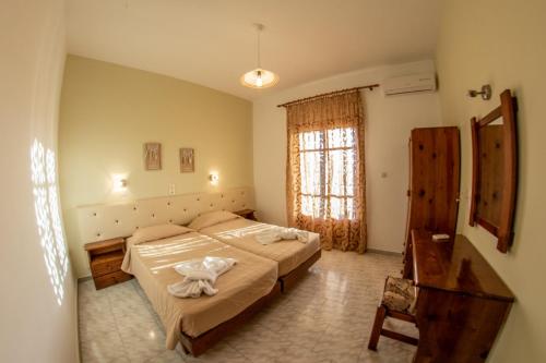 ein Schlafzimmer mit einem großen Bett und einem Fenster in der Unterkunft George Apartments in Arillas