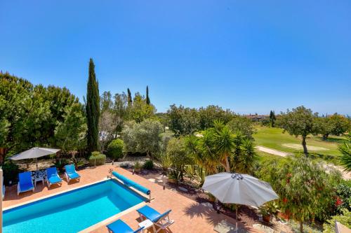 an outdoor swimming pool with chairs and umbrellas at 4 bedroom Villa Kellia with private pool, Aphrodite Hills Resort in Kouklia