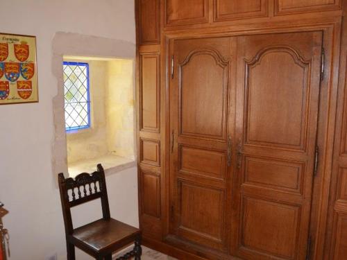 a bathroom with a large wooden cabinet and a chair at Maison spacieuse à Saint-Martin-des-Entrées avec jardin in Saint-Martin-des-Entrées
