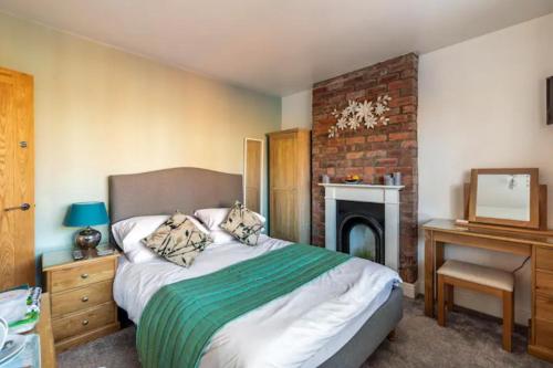 1 dormitorio con 1 cama grande y chimenea en Camaraderie Guest House en York