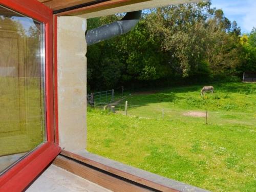 a view of a horse in a field from a window at Maison spacieuse à Saint-Martin-des-Entrées avec jardin in Saint-Martin-des-Entrées