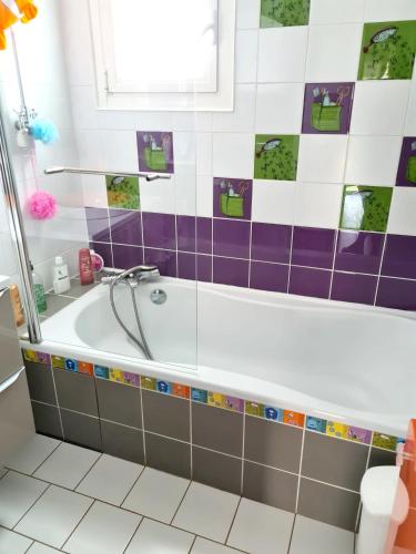 une salle de bain avec baignoire et carrelage violet et blanc dans l'établissement Villa élégante à Ollioules + Piscine, à Ollioules