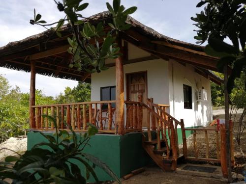 una pequeña casa con una gran terraza de madera en Shambala Paradise, en Siquijor