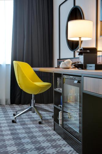 a yellow chair sitting in front of a desk at Radisson Blu Hotel Amsterdam Airport, Schiphol in Schiphol