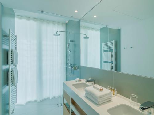 a bathroom with a sink and a mirror at Falkensteiner Residences Jesolo in Lido di Jesolo