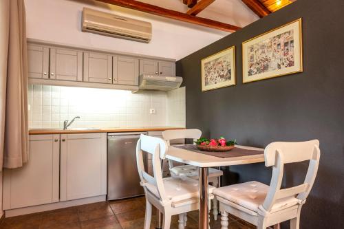 a kitchen with a table and chairs and a sink at Gardenia Studios in Mouresi