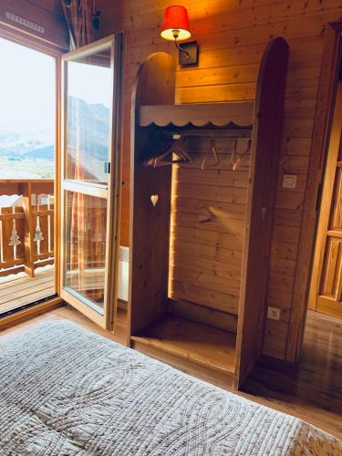 Cette chambre comprend un lit et une grande fenêtre. dans l'établissement Chalet cosy au cœur du Dévoluy avec vue magnifique, à Saint-Étienne-en-Dévoluy