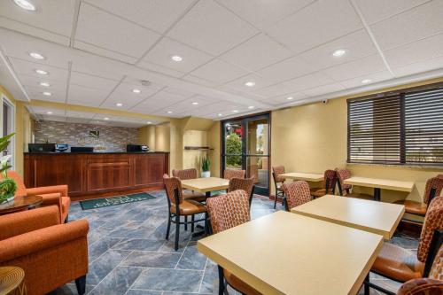 a waiting room with tables and chairs and a kitchen at HIBISCUS Inn & Suites in Absecon