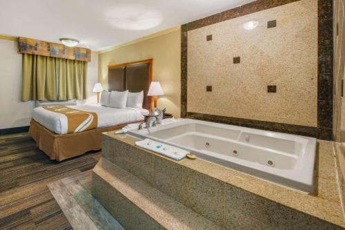 a hotel room with a bed and a bath tub at Hibiscus Inn & Suites in Absecon