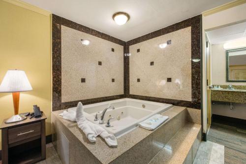 a bathroom with a bath tub with a sink at HIBISCUS Inn & Suites in Absecon