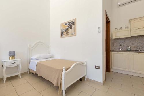 a small bedroom with a bed and a kitchen at Villa La Paiara by Perle di Puglia in Borgagne